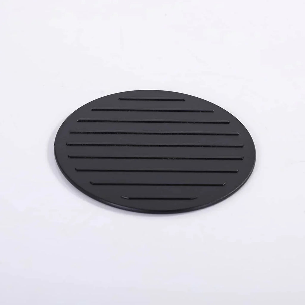 Black circular mat with ribbed texture on a white background