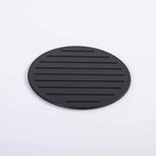 Black circular mat with ribbed texture on a white background