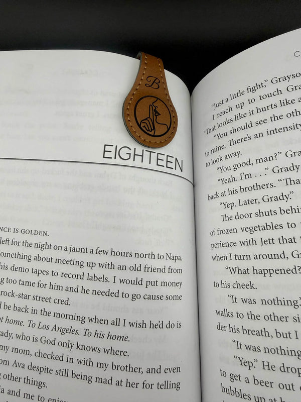 Open book with a leather bookmark on a black background
