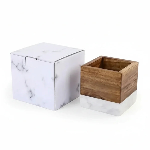 Wooden cube with marble base and packaging box on a white background