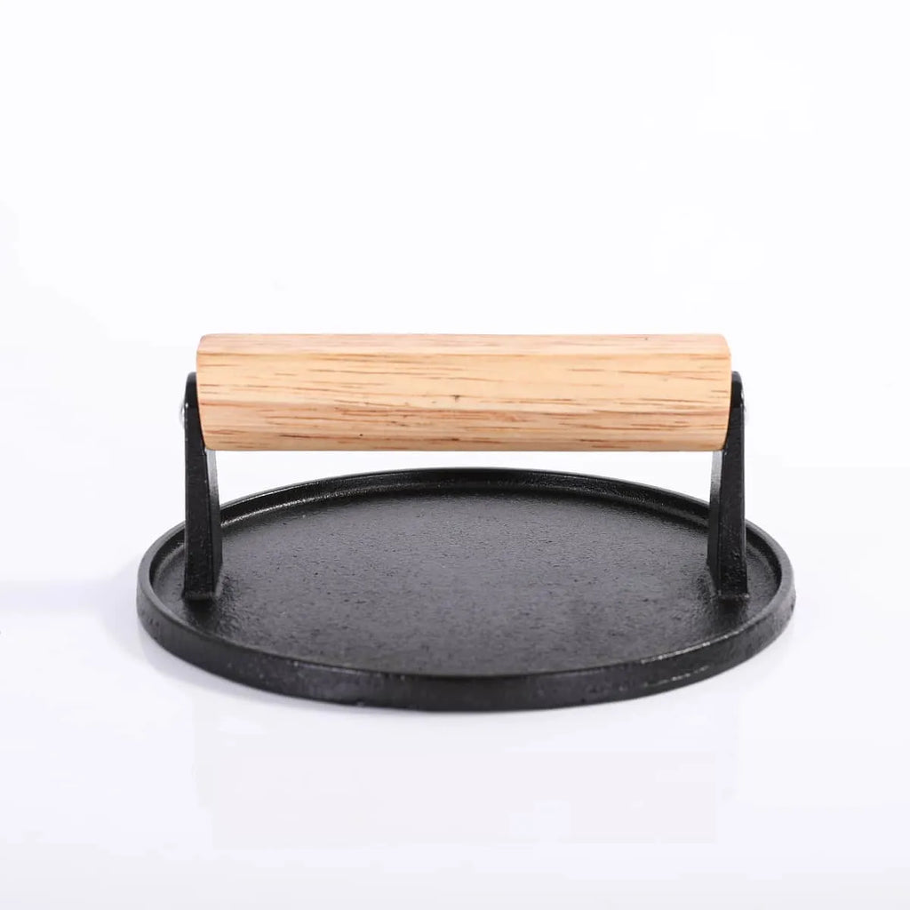 Cast iron tortilla press with wooden handle on a white background