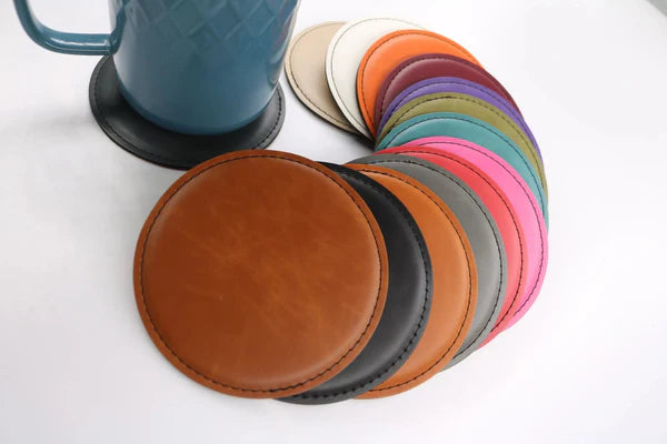 Round leatherette coasters in assorted colors, shown in a fan layout next to a mug – Heritage Collection